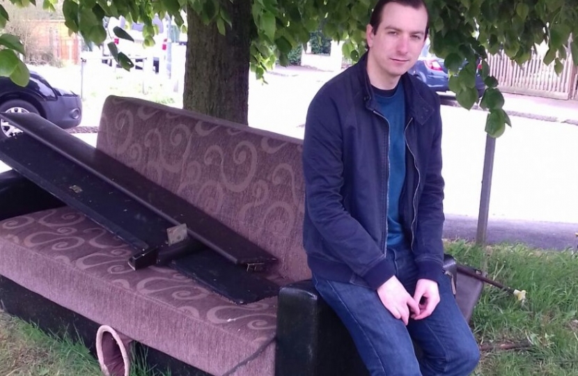 Ross Archer on a discarded sofa